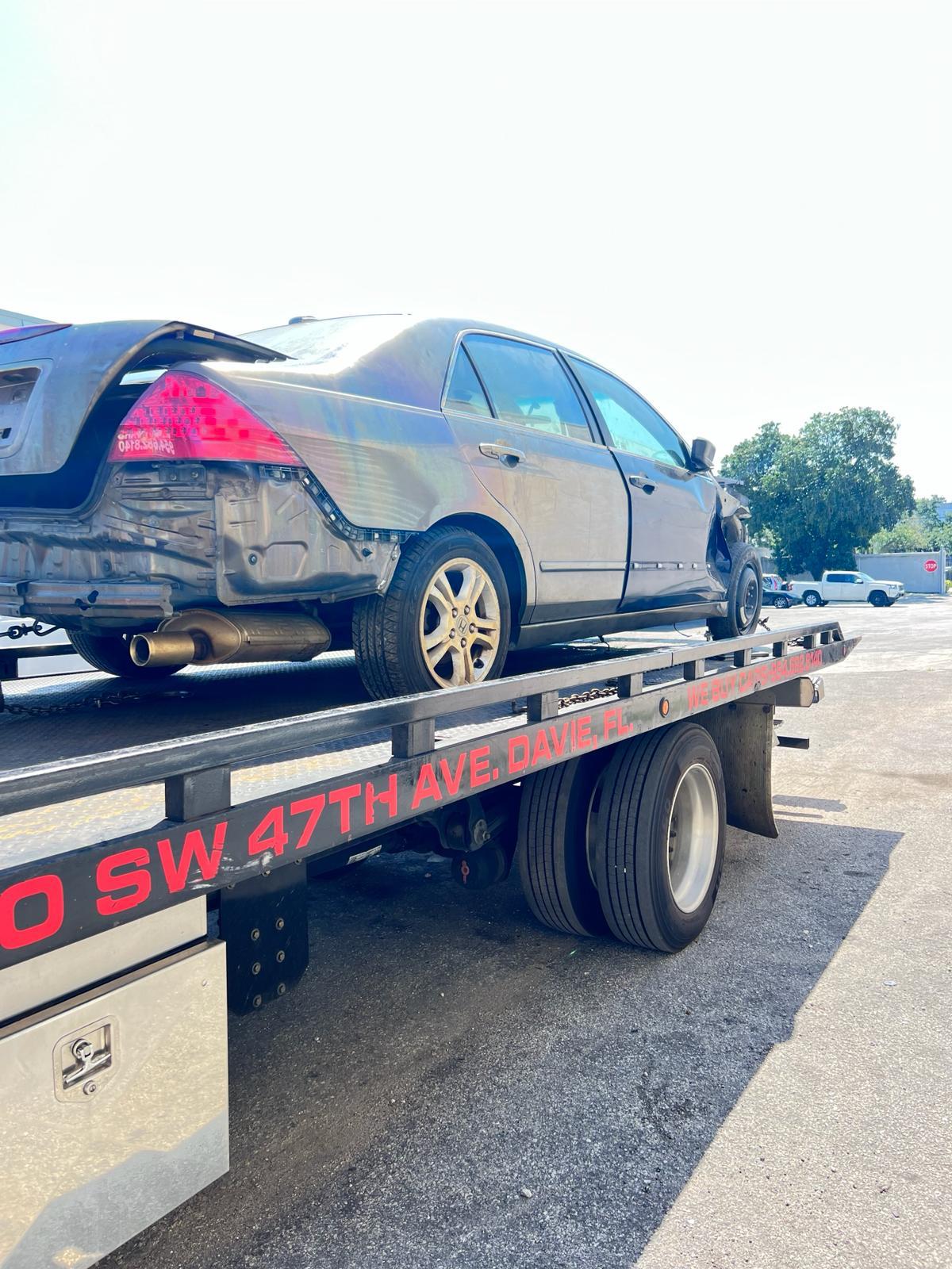 Junk car being picked up on a flatbed tow truck